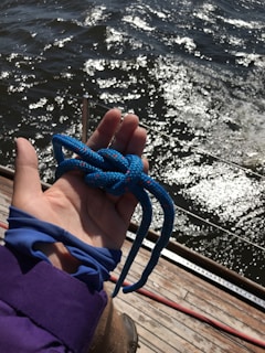 person holding blue shoe lace