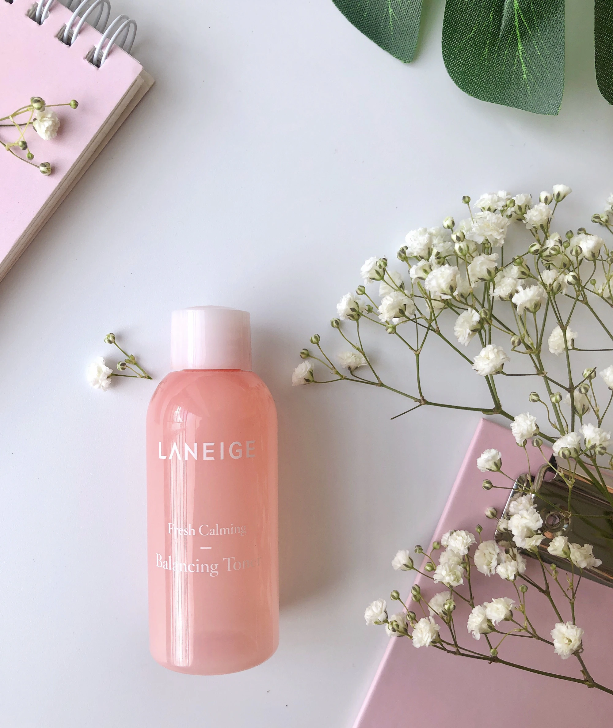 Pastel pink light across a minimalist shelf