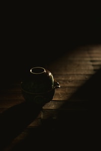 A close-up of a beautifully crafted ceramic teapot on a wooden table.