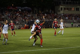 A lively local soccer match in a neighborhood public court with players competing passionately under the evening sun.