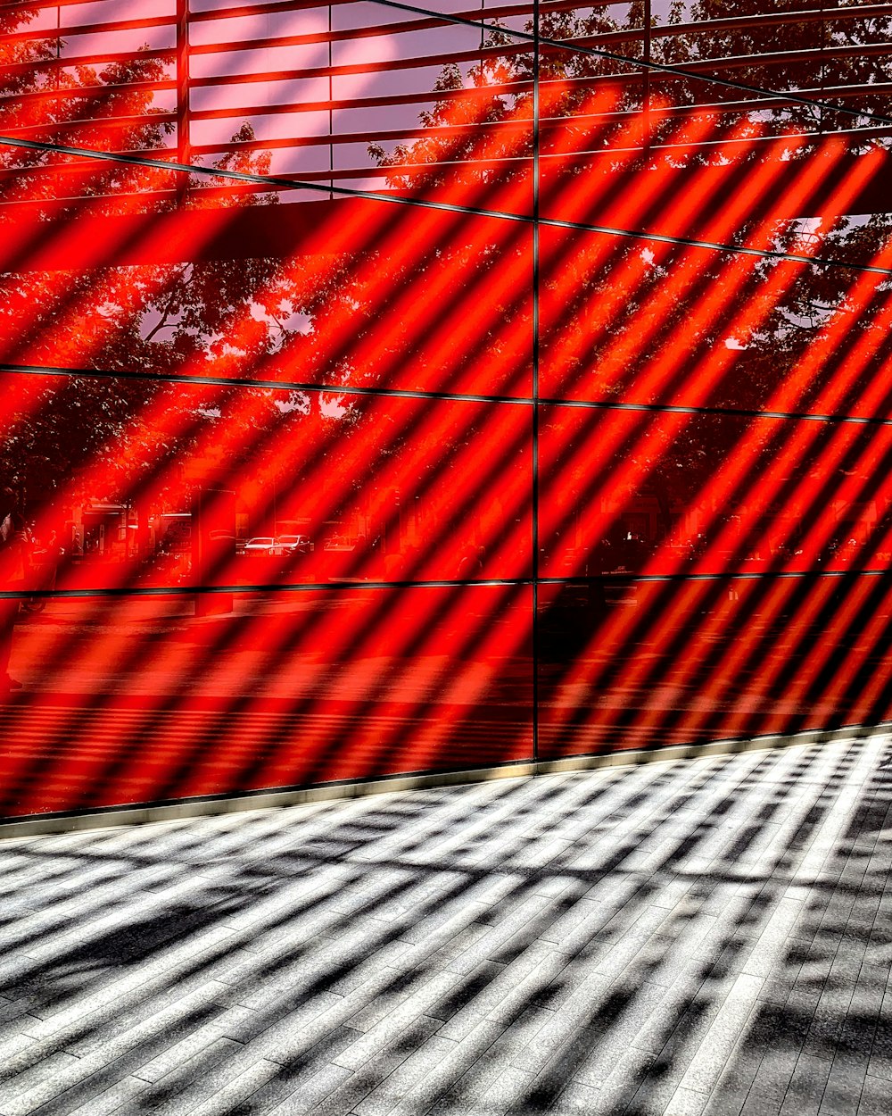 a building with a red wall and trees in the background