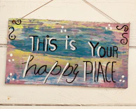 Close-up of a handcrafted MDF name plaque with soft pastel paint and whimsical fonts.