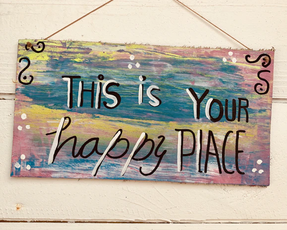 A vibrant pallet board sign featuring layered decoupage papers and glitter accents.