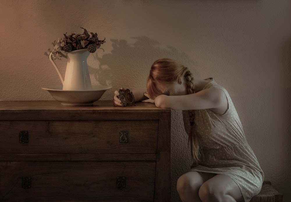 woman sitting beside drawer