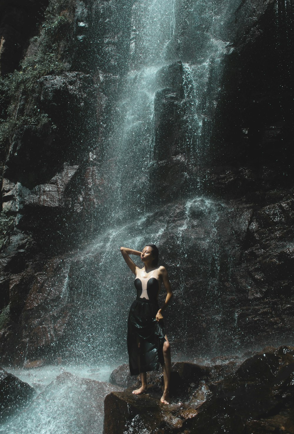 woman standing in front of water falls