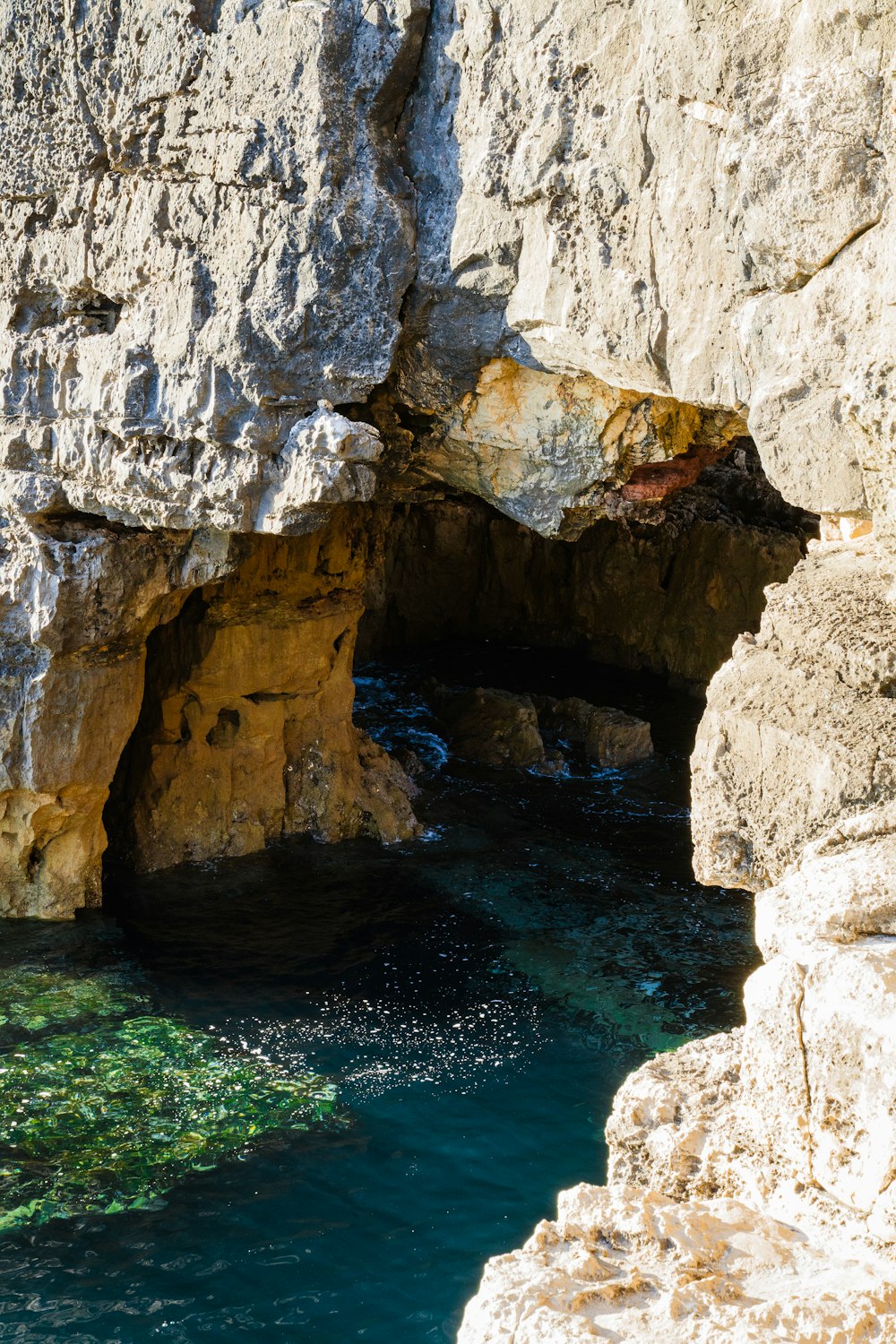 gray cave in body of water