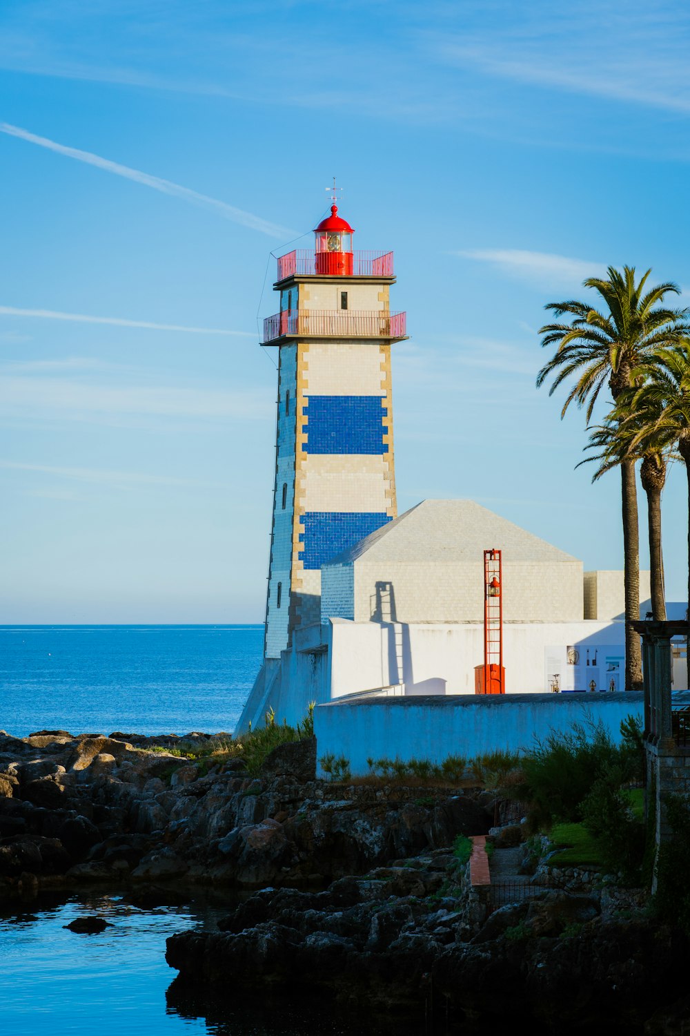 white concrete lighthouse near shore during daytime