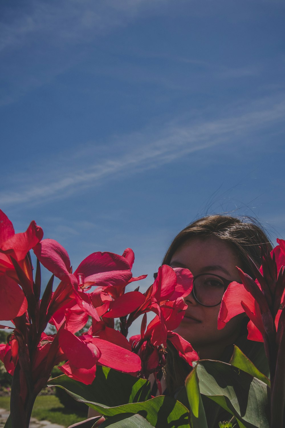 woman standing on the red petaled flower