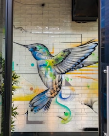 A vibrant neo-traditional tattoo featuring a sage green hummingbird with cream accents.