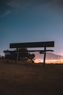 Evening city skyline with a Lumina Apparel tote bag resting on a bench nearby.