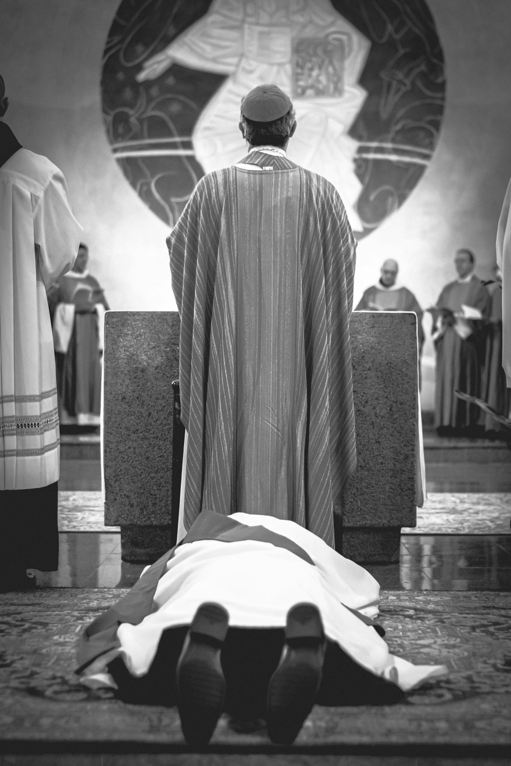 person lying on floor while another man standing beside him