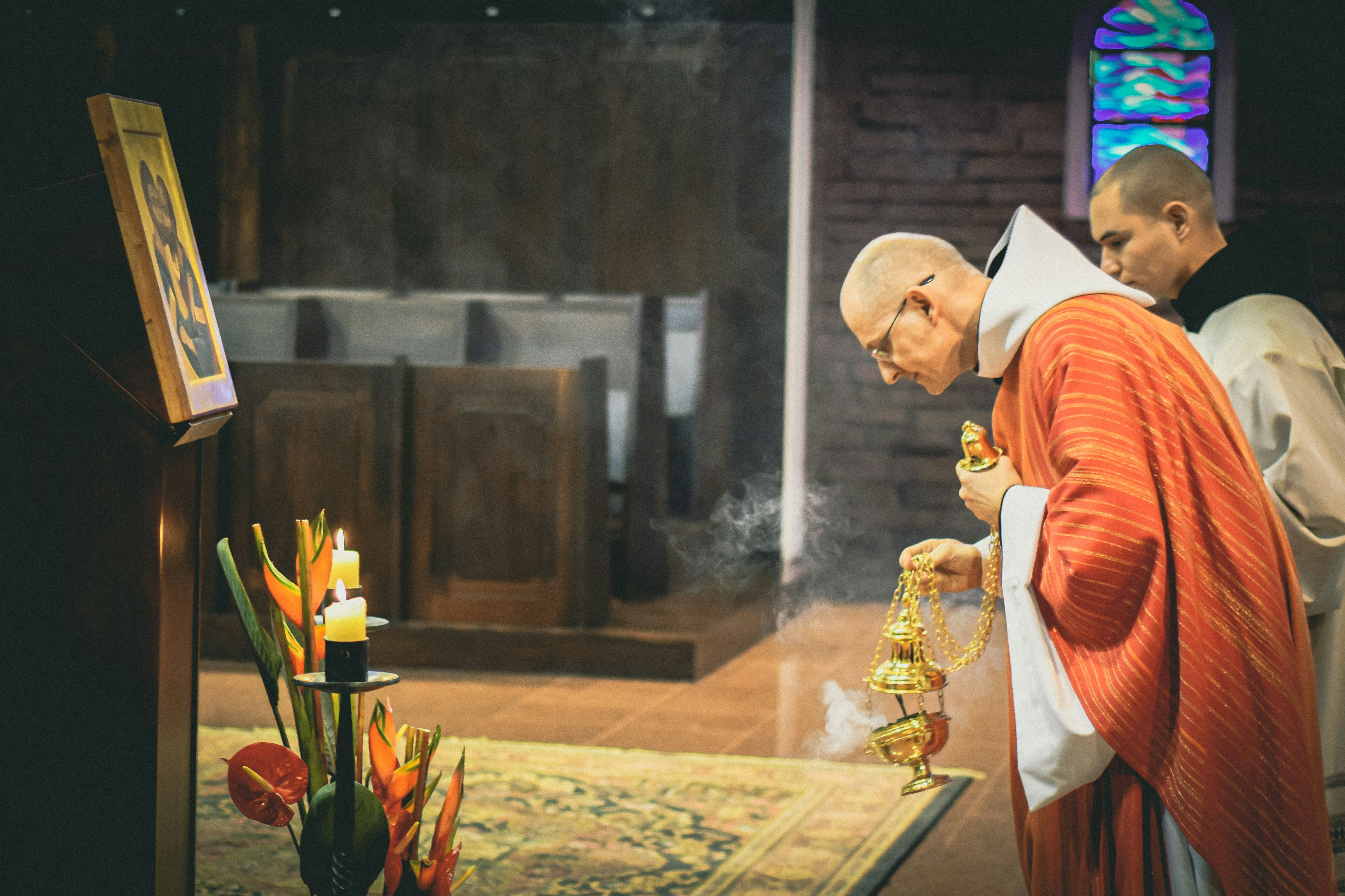 priest holding brass-colored censer