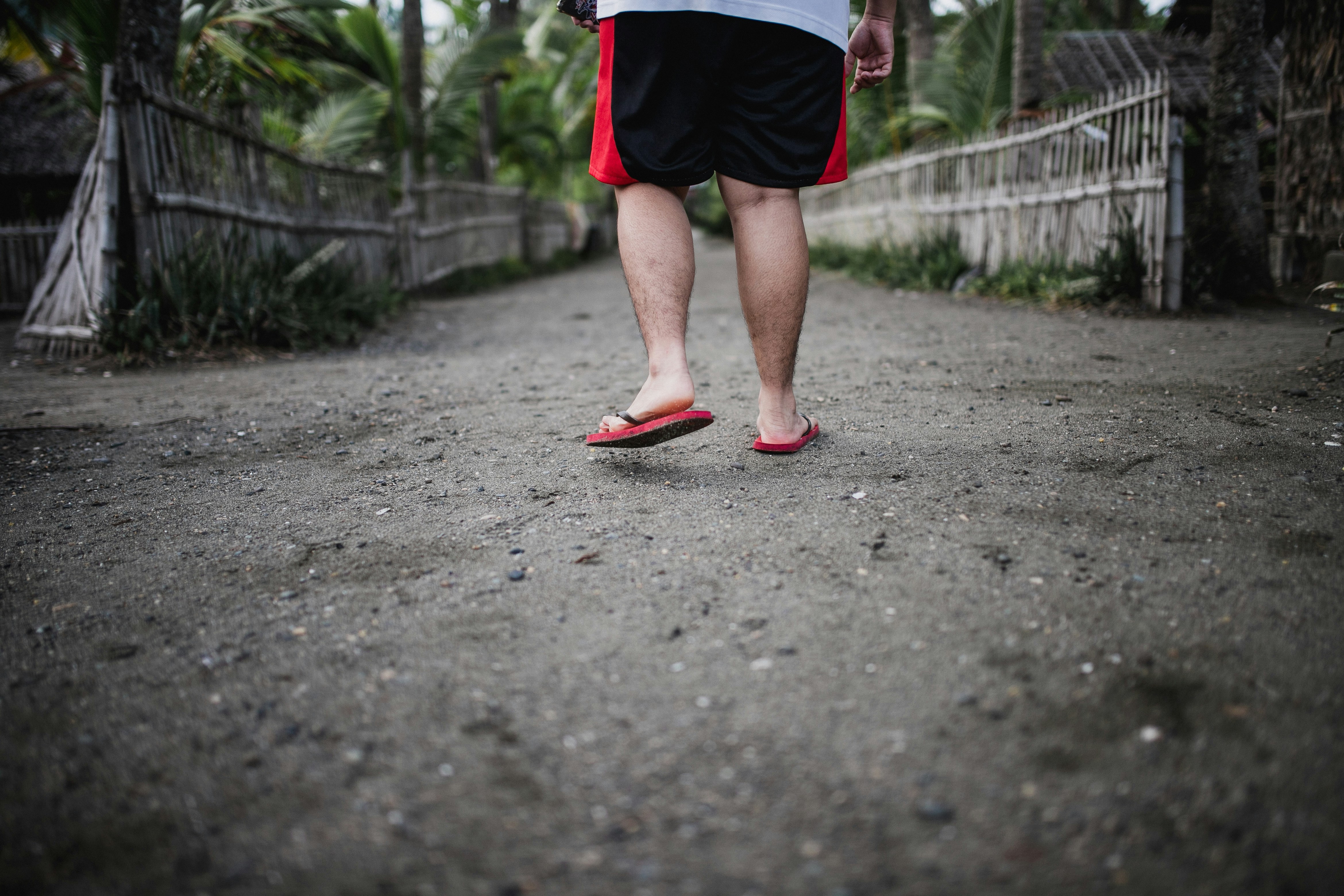 person wearing pair of red rubber flip flops