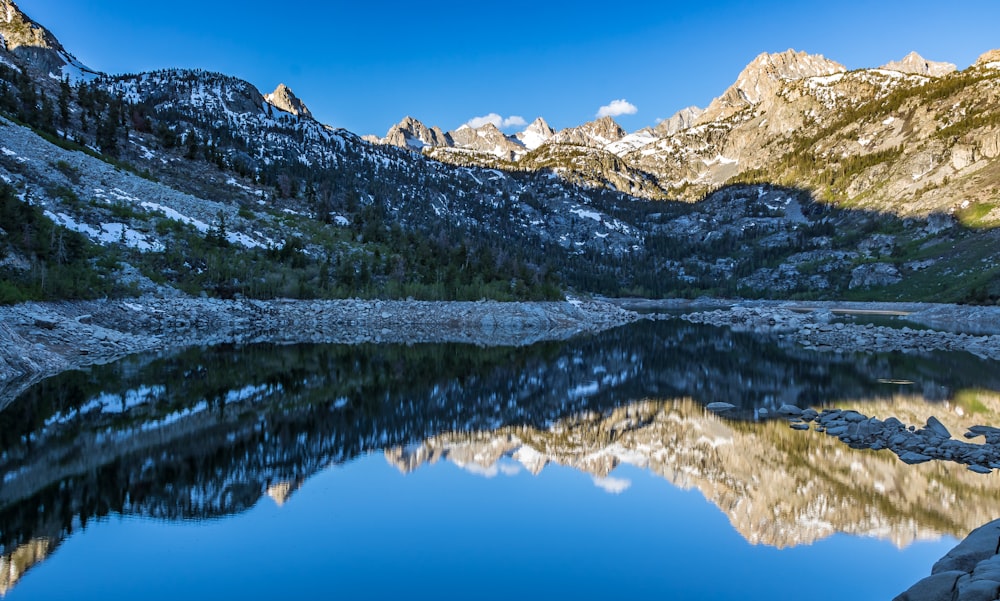 rock mountain reflecting on water