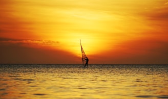A vibrant sunset over a Chilean beach with windsurfers catching the last waves.
