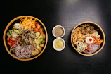 A close-up of various sauces and toppings ready for poke bowls.