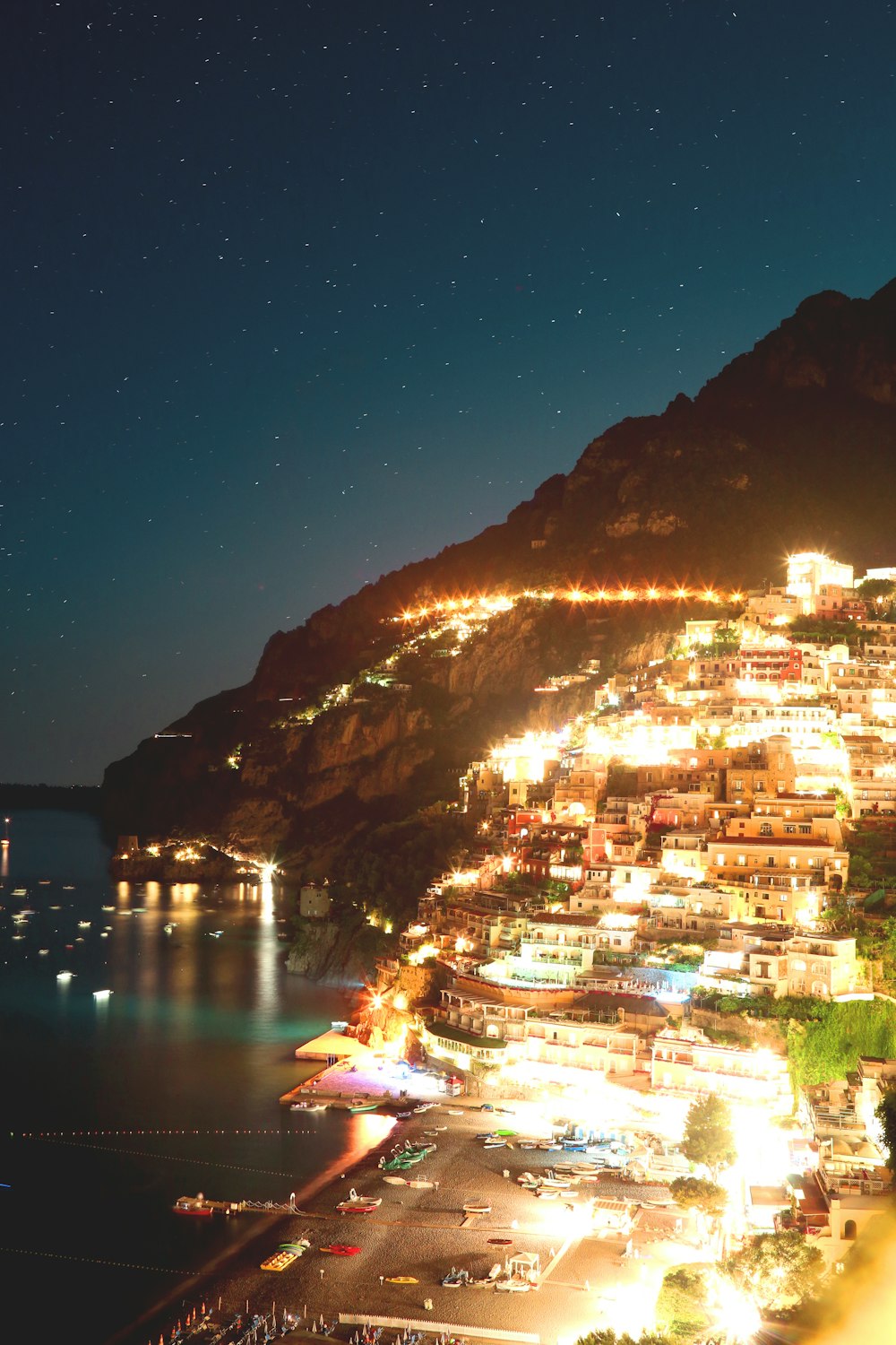 aerial photography of building on mountain beside seashore during nighttime