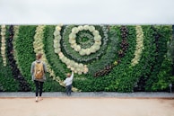 a woman and a child are standing in front of a green wall