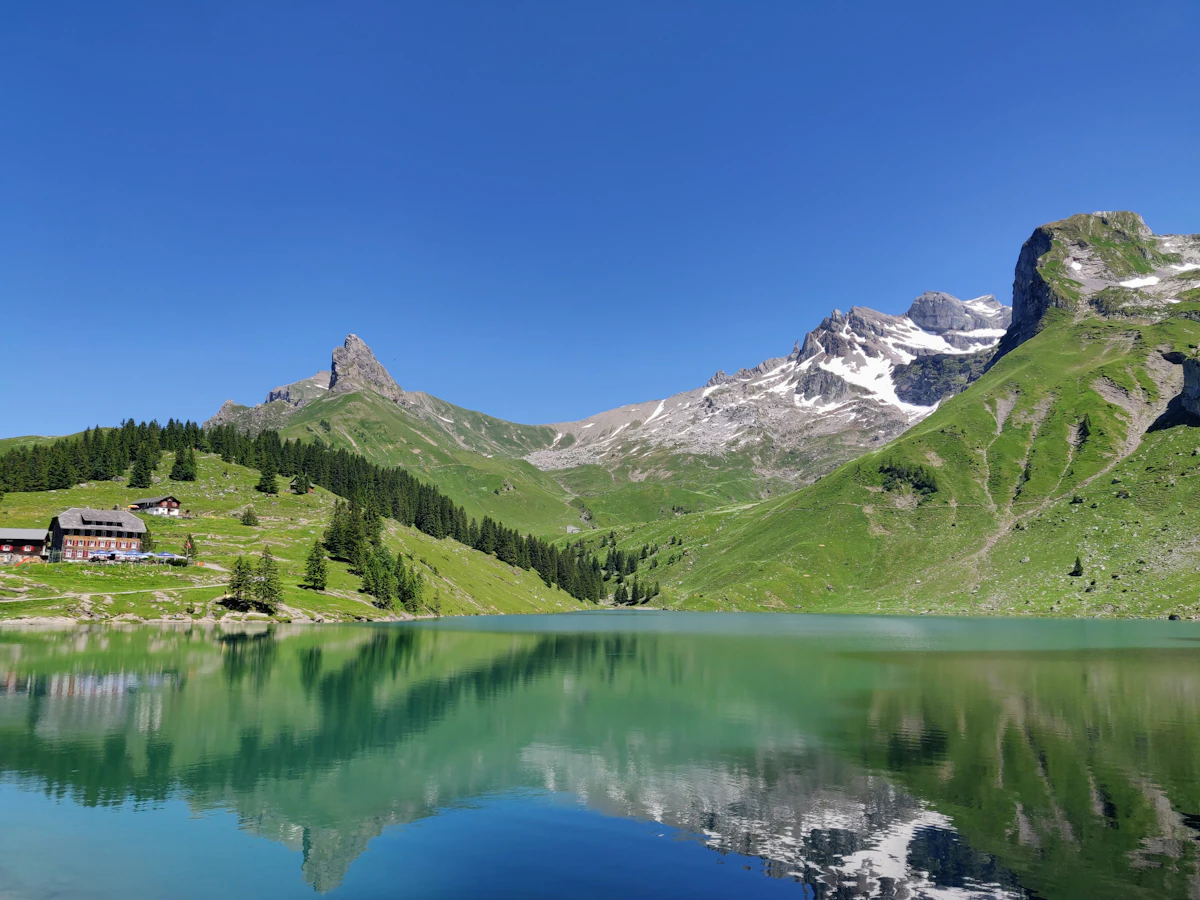 Engadin valley in October with golden larch forests reflected in Lake Silvaplana at morning light