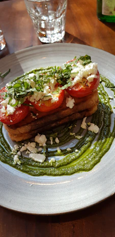 A vibrant plate of grilled Mediterranean vegetables drizzled with olive oil and fresh herbs from Olivaire's farm.