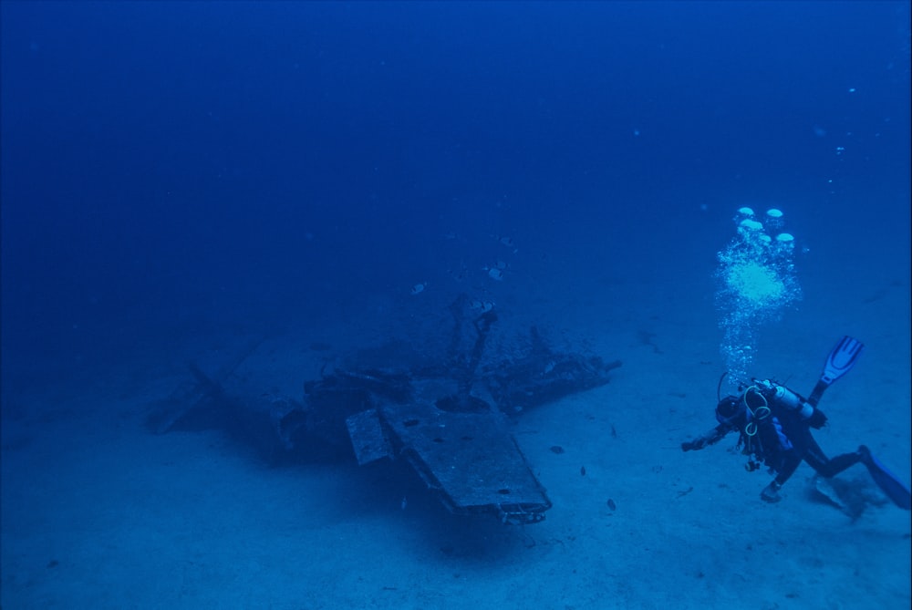 diver beside wreck plane under the ocean