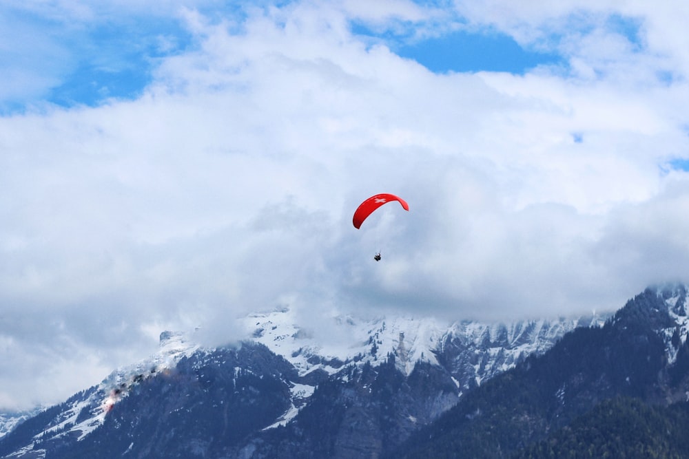 person riding red parachute midair photo