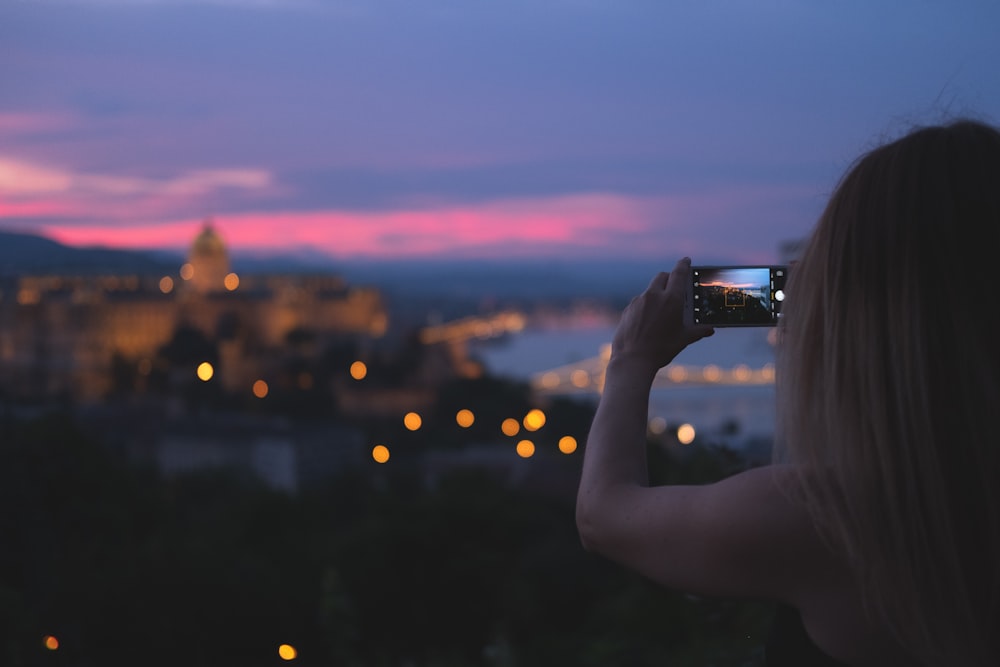 woman using smartphone taking photo