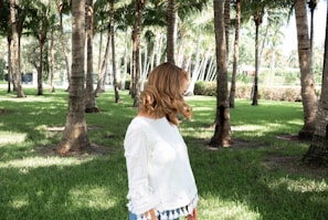 Delicate white mesh top layered over a black sports tank, with sunlight filtering through palm leaves