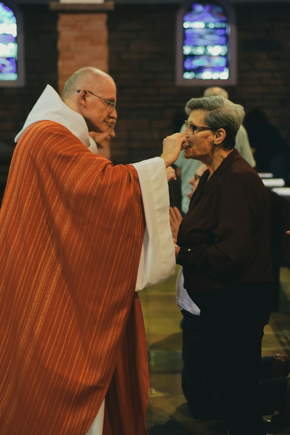 Frau kniet nieder, während sie den Leib Christi während der Messe empfängt