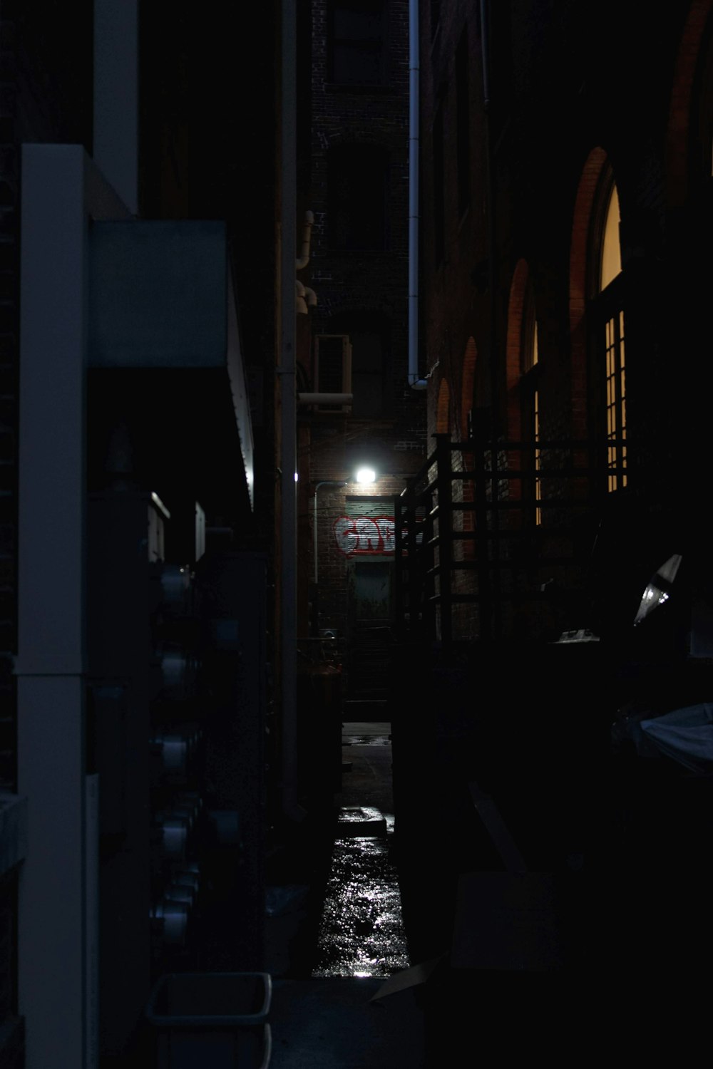 a dark alley way with a street light at night