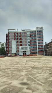 Photo of Mamdouh Boshnaq General Contracting office building in Jeddah with workers discussing plans outside.