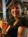 A happy restaurant owner holding a glass of fresh juice in a cozy dining setting.