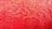 Intricate lace fabric with detailed floral patterns, showcasing a variety of curved and circular designs. The texture is highlighted by the fine embroidery and the vibrant red color of the material, which reflects light softly.