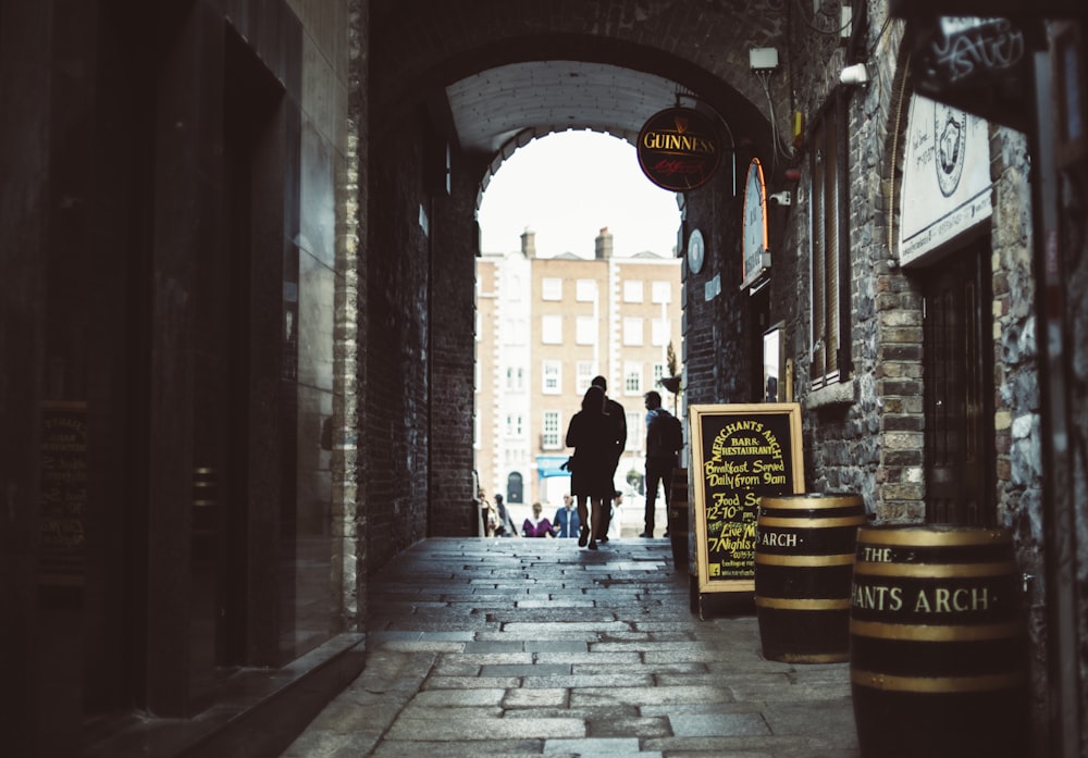 silhouette of people walking on walkway under building