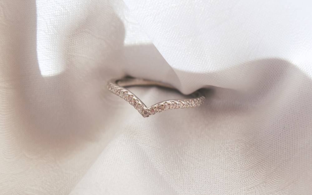 a close up of a diamond ring on a white cloth