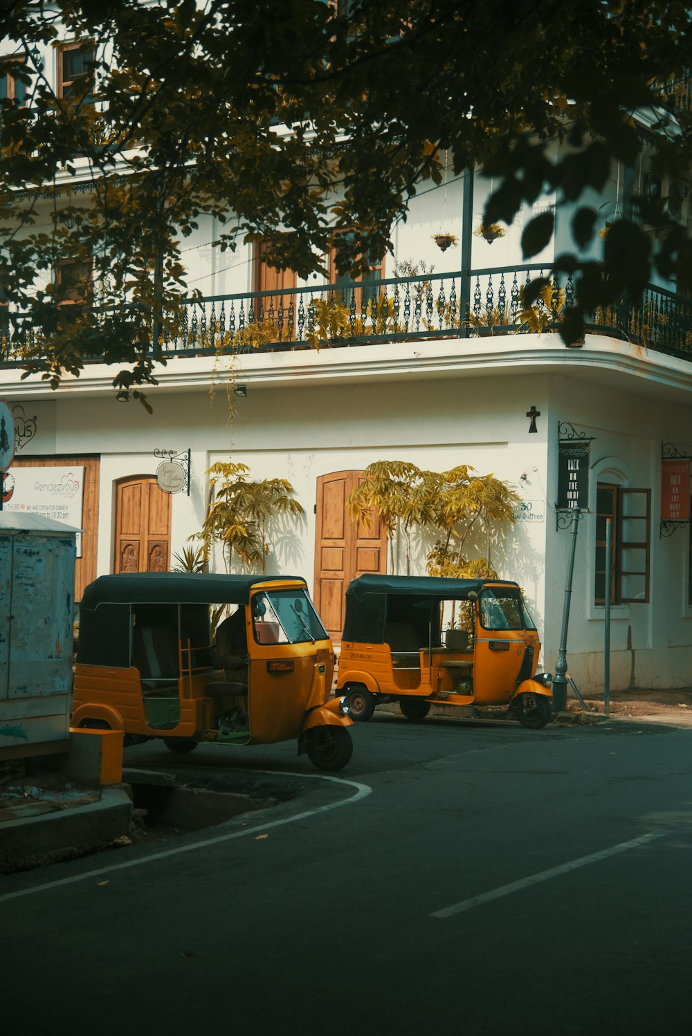 two yellow autorickshaws park near apartment