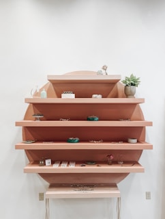 Hands gently arranging items on a wooden shelf to create balanced energy flow