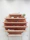 A man arranging vastu shastra items on a wooden shelf with a peaceful expression.