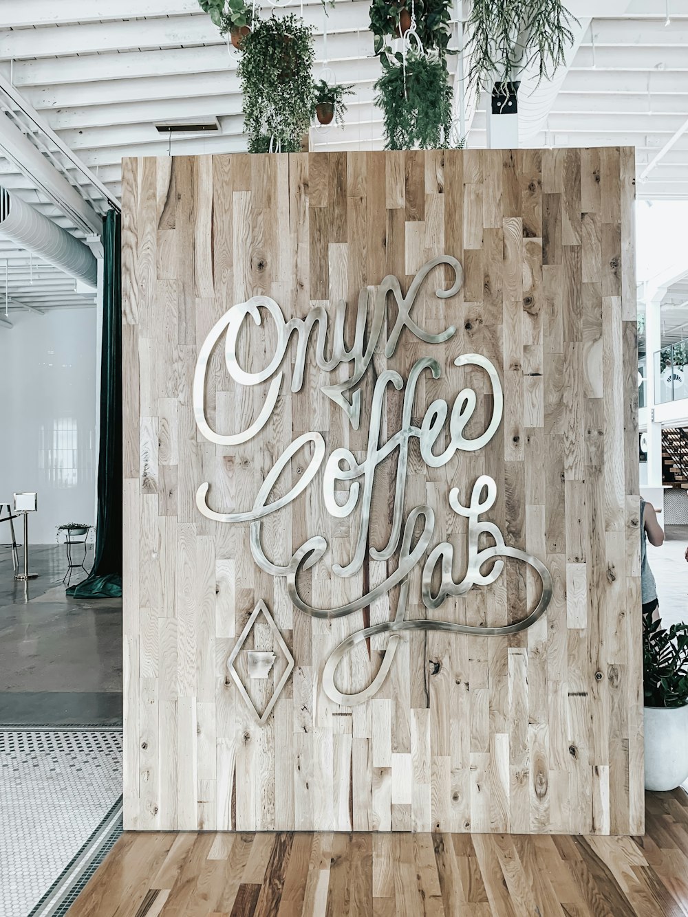 brown wooden wall board with metal letter signage inside coffee shop