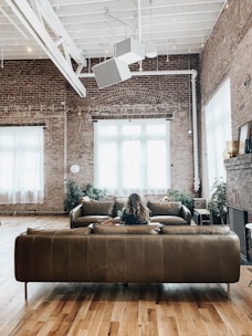 Cozy loft interior with exposed brick walls and large windows.