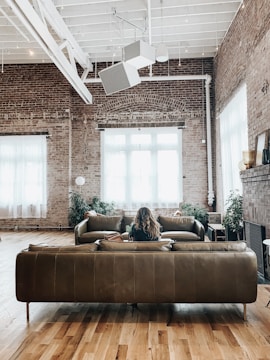 Interior view of a cozy, well-lit loft with exposed brick walls.