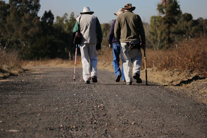three people walking road during daytime