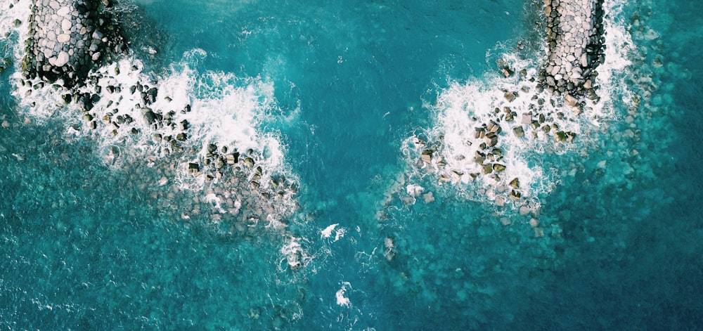 aerial photography of rocks and body of water during daytime