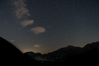 A dreamy landscape featuring rolling hills under a starry sky.