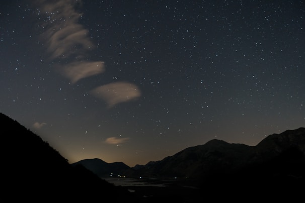 A dreamy landscape featuring rolling hills under a starry sky.