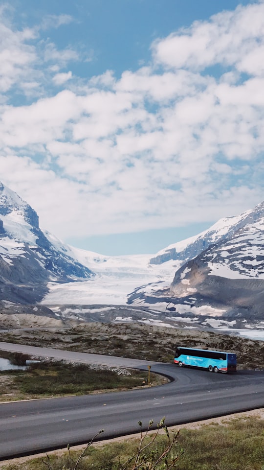 blue bus traveling on road during daytime in Athabasca Glacier Canada