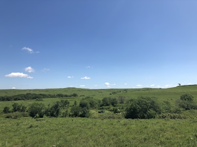 A wide open plot of land with a backdrop of Govardhan hills under a clear sky.