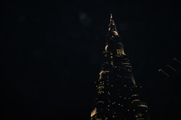 Nighttime shot of a completed high-rise building illuminated against the dark sky.