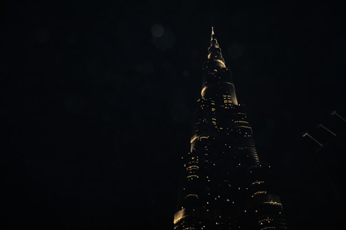 Nighttime shot of a completed building illuminated against the dark sky.