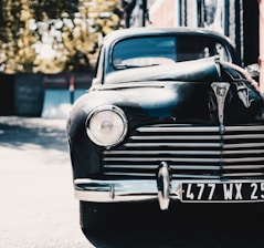 A vintage car parked in a scenic location, showcasing its timeless design.